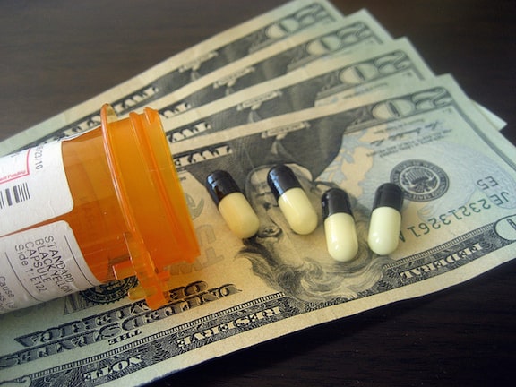 Photo of prescription pills over dollar bills