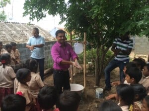 Demonstrating how to use the tippy-tap hand-washing station