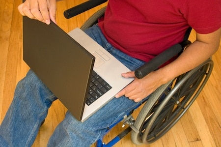 men in wheelchair with laptop computer
