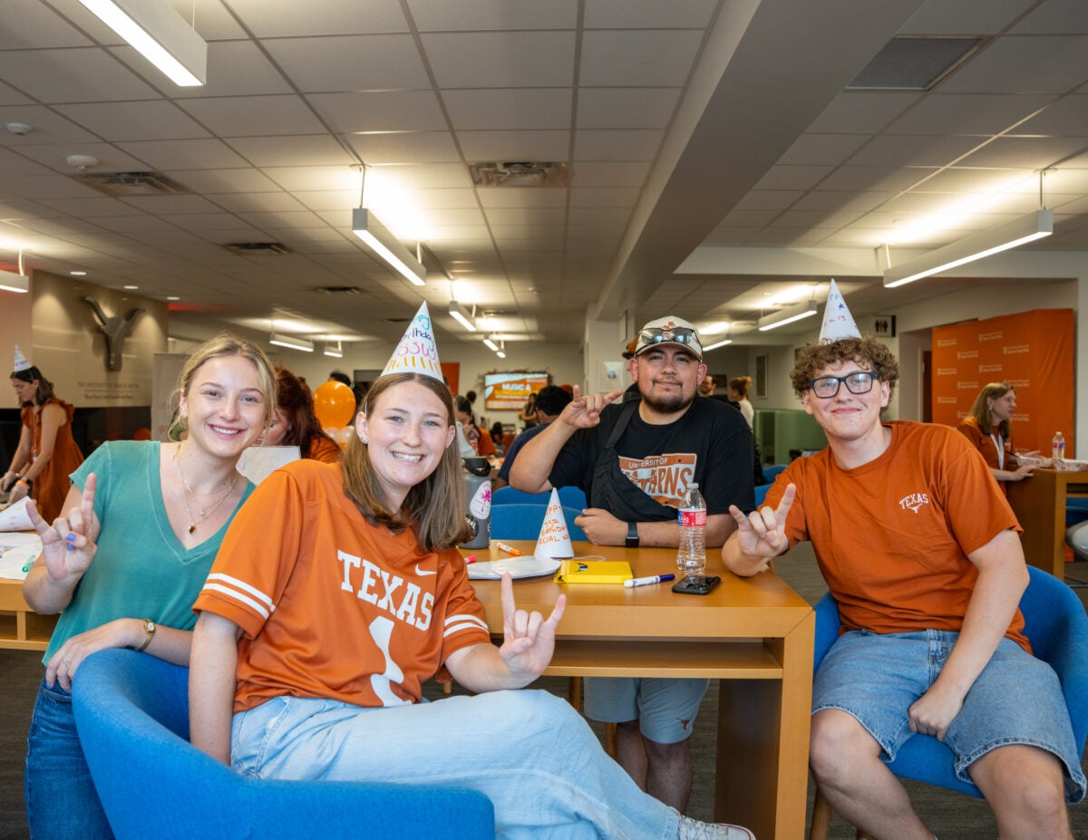 Students throwing the Hook Em sign